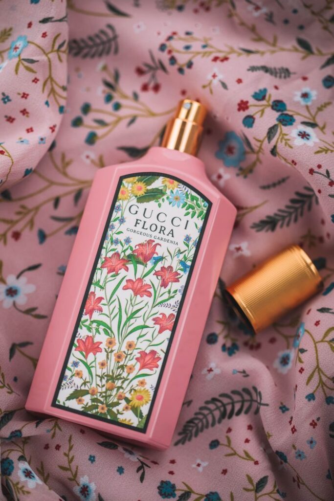 Close-up of Gucci Flora perfume bottle on floral fabric, showcasing opulence and elegance.